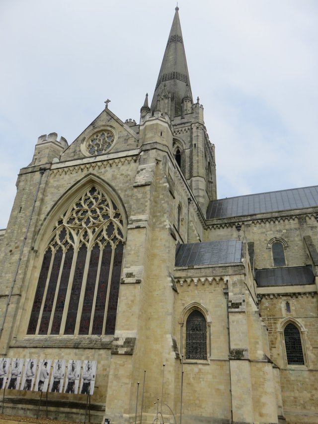 The outside of the cathedral from the cloisters with some more tat plastered on the walls.