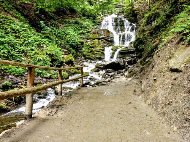 Road along the river to the waterfall