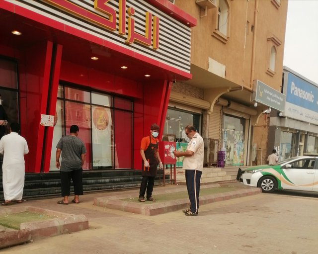 Waiter of the restaurant are staying outside waiting to deal with the customer’s order.