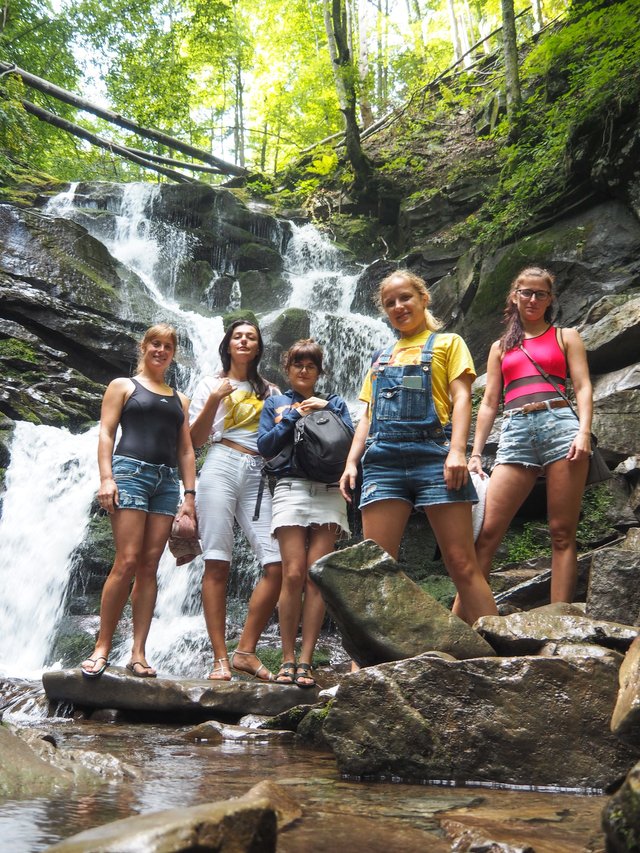 Girlish band near a beautiful waterfall