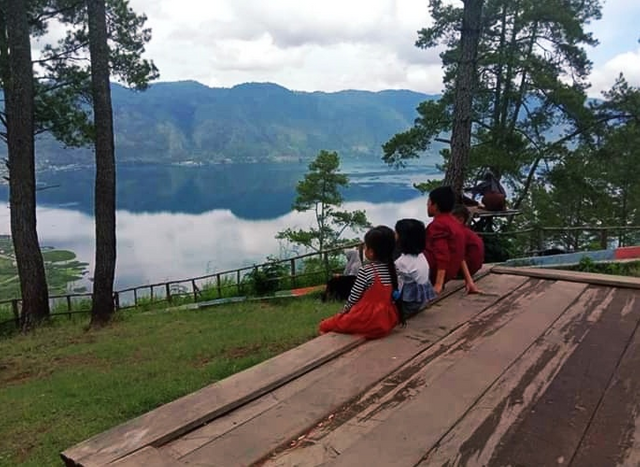 Image Photograph of several young children who are looking at the panoramic beauty of the lake.