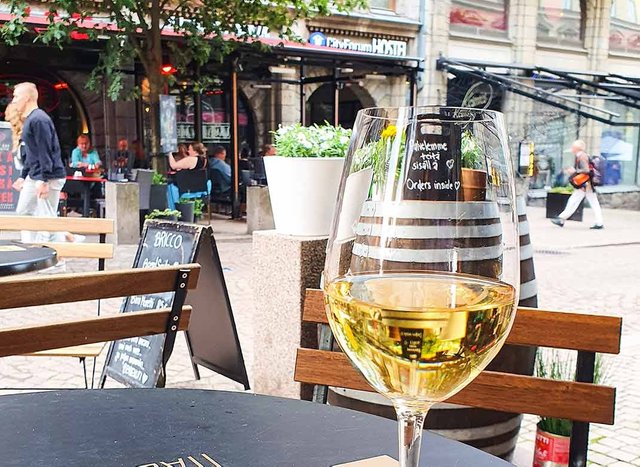 Glass of white wine is Helsinki terrace ba