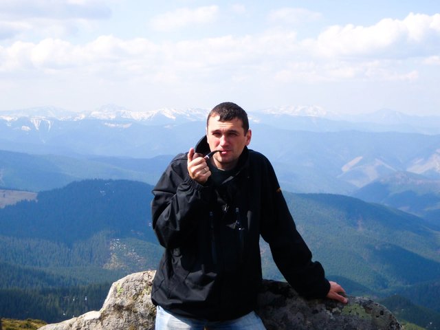 Photo with a pipe against the background of distant mountains