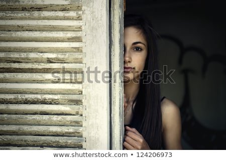 girl-looking-through-window-shutter-450w-124206973.jpg