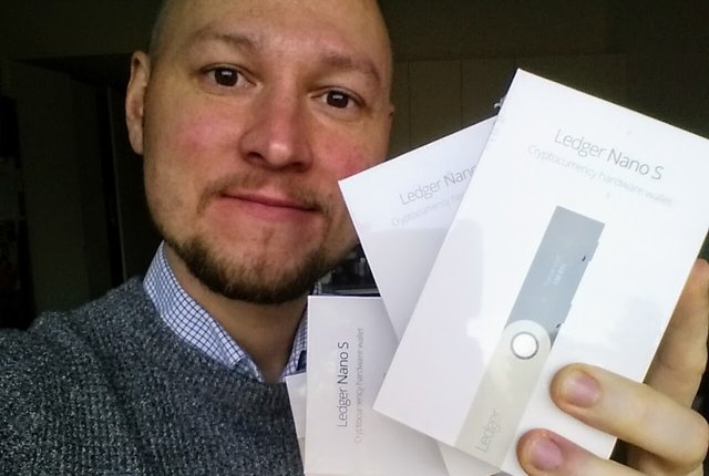 Oleg holding a few boxes with Ledger Nano S cryptocurrency hardware wallets