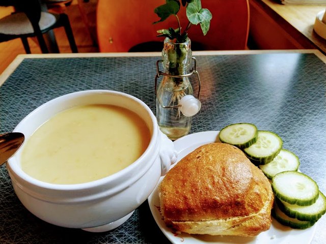 Photo of a bowl of soup and a bun of bread