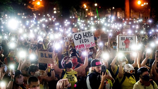 Black Lives Matter protesters hold their phones aloft in Portland, Oregon, 20 July 2020