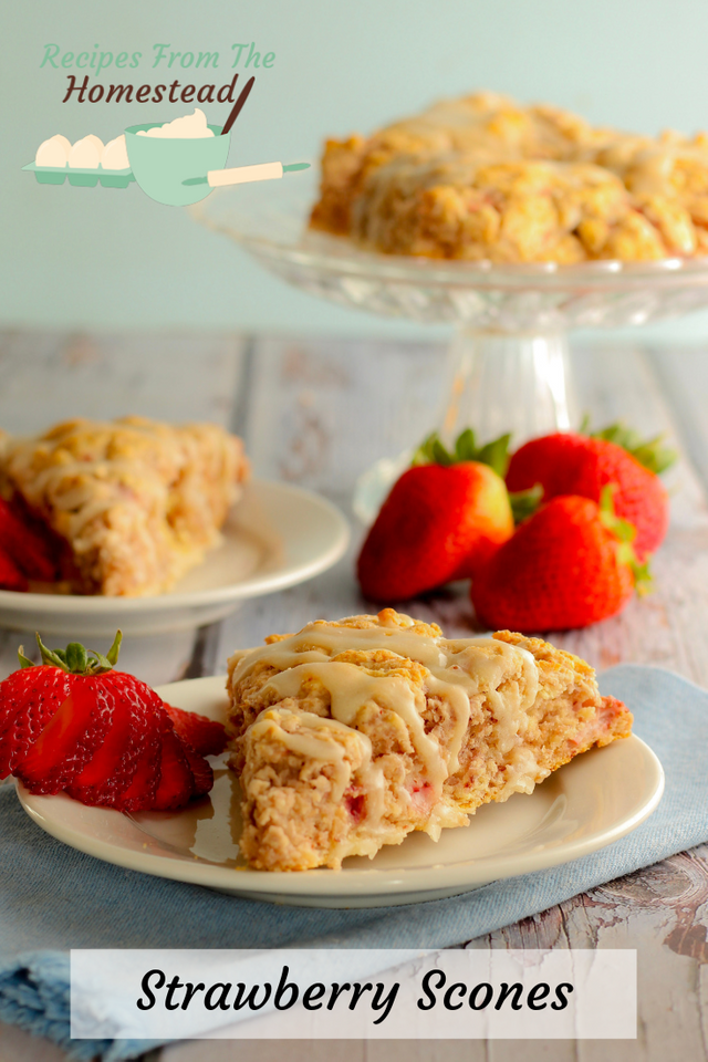 2 strawberry scones, each on a white plate with strawberries next to them. 