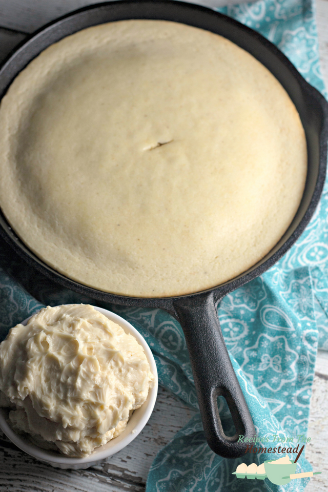 white skillet cornbread with maple butter in white bowl on side