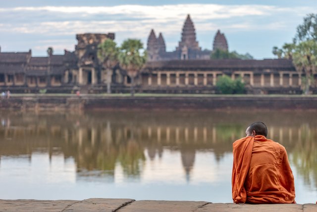 A monk watches the tourists at Angkor Wat