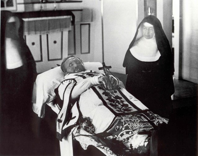 Father_Damien_on_his_funeral_bier_with_Mother_Marianne_Cope_by_his_side.jpg