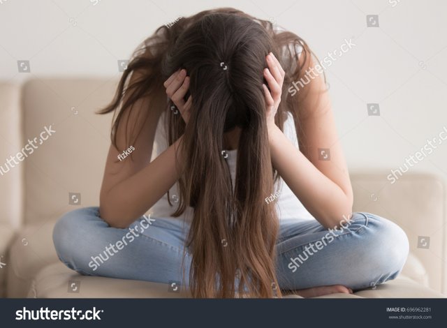 stock-photo-depressed-teenager-sitting-holding-head-in-hands-stressed-sad-young-woman-having-mental-problems-696962281.jpg