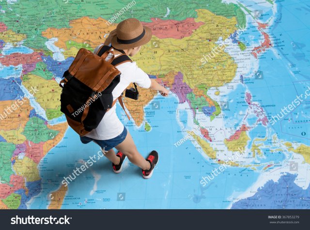 women-traveler-is-planning-a-tour-her-standing-on-the-world-map-she-points-to-the-map.jpg