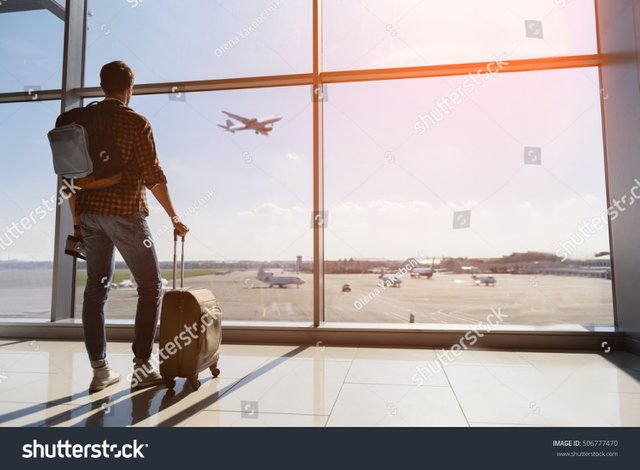 zcalm-male-tourist-is-standing-in-airport-and-looking-at-aircraft-flight-through-window-he-is.jpg