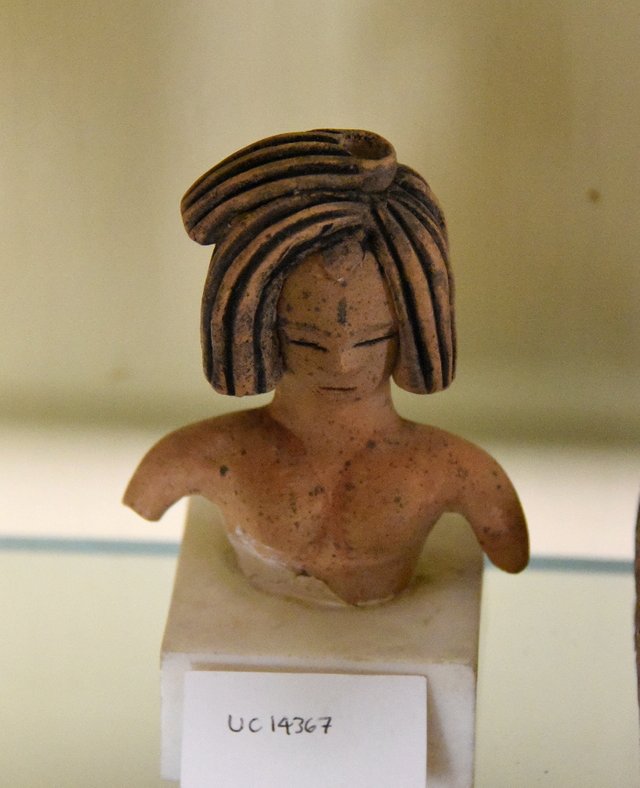 Upper_torso_of_a_woman's_figurine._Slit_eyes_and_mouth._She_wears_an_elaborate_headdress._Pottery_fragment._Ramesside_period._From_Egypt._The_Petrie_Museum_of_Egyptian_Archaeology,_London.jpg