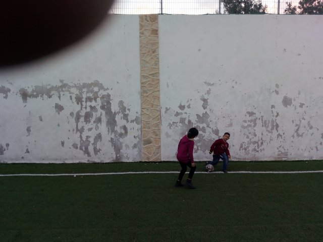 Un frère et une soeur jouant au football
