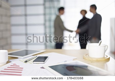 stock-photo-close-up-of-business-items-with-people-meeting-in-background-178403168.jpg