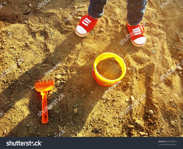 stock-photo-child-playing-in-the-sand-with-a-bucket-632786918.jpg