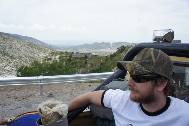 Kurt in the back of a ute, desert and mountains behind