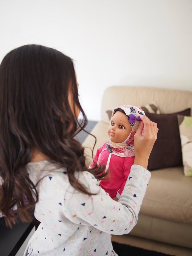 A young girl plays with a Salam Sisters doll named Maryam.&nbsp;