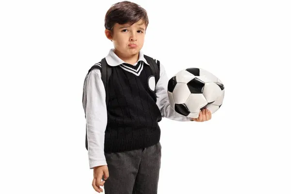 Disappointed little schoolboy with a deflated football — Stock Photo, Image