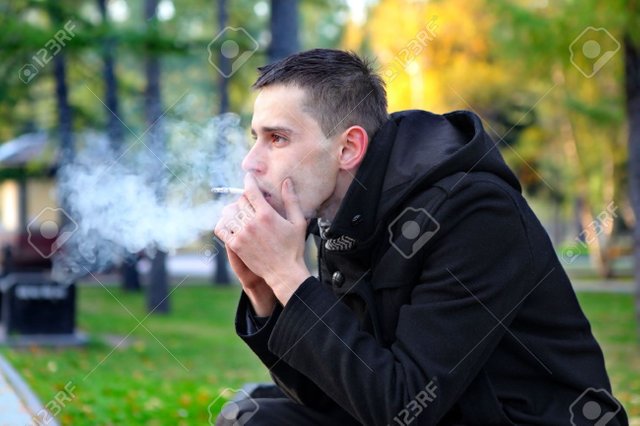 18205951-sad-man-smoking-cigarette-in-the-autumn-park-Stock-Photo.jpg