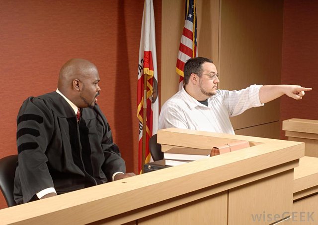 man-pointing-in-courtroom-with-judge.jpg