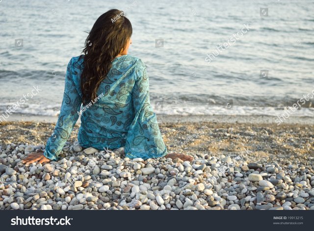 stock-photo-a-rear-view-of-a-beautiful-indian-girl-sitting-alone-on-a-beach-and-looking-out-to-sea-19913215.jpg