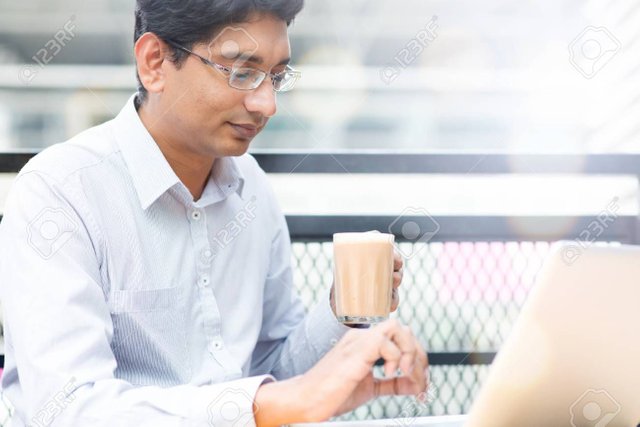 38790358-asian-indian-businessman-using-laptop-computer-while-drinking-a-cup-hot-milk-tea-outdoor-cafe-.jpg