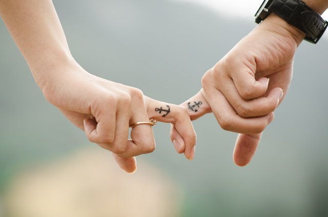 young-couple-holding-hands-with-tatoos-on-fingers.jpg