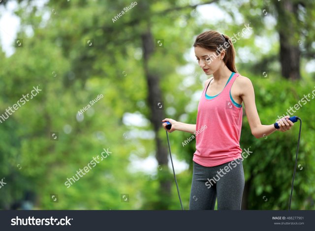 stock-photo-young-woman-with-skipping-rope-in-park-488277901.jpg