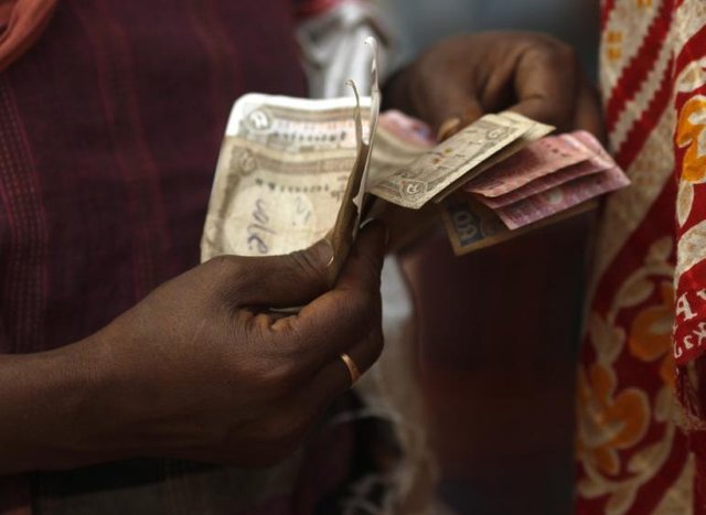 244029-a-woman-counts-out-bangladeshi-banknotes-in-dhaka.jpg