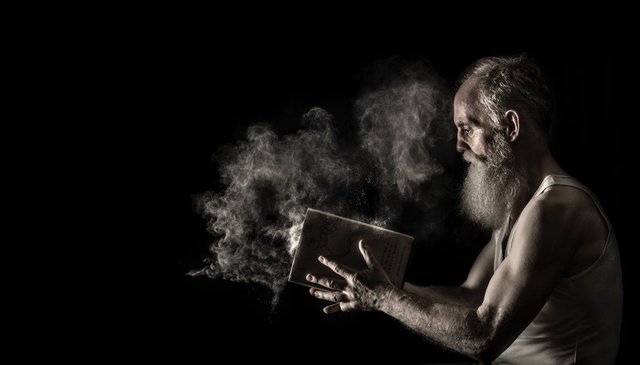 Man in White Tank Top Holding Book.jpeg