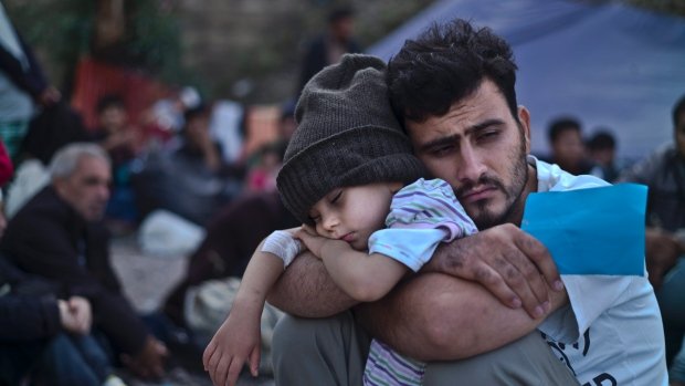 A-Syrian-refugee-child-sleeps-in-his-fathers-arms-on-the-northeastern-Greek-island-of-Lesbos.jpg