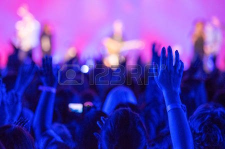 39564098-open-hands-raised-up-in-foreground-with-anonymous-guitar-player-on-stage-in-background.jpg