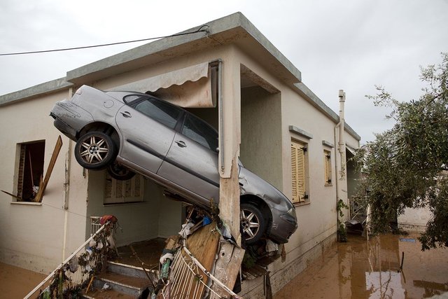 A Car is Wedged Into The Entrance of a Flooded House.jpg