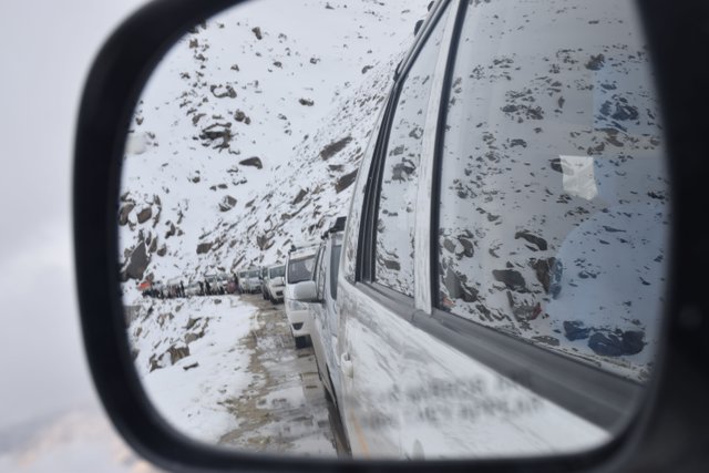 Mirrored image of vehicles stuck in snow