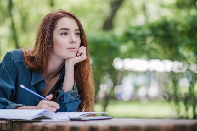 girl-lying-on-table-in-park-writing_23-2147657089.jpg