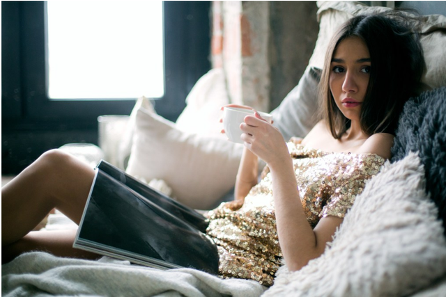 Woman in Sequinned Beige Off-shoulder Dress Laying on Bed.png