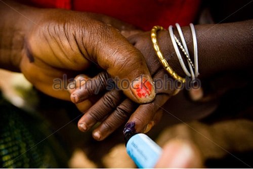 a-community-volunteer-marks-the-finger-of-a-child-with-ink-during-bth7d7.jpg