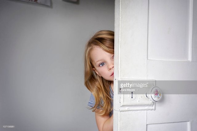 girl-peeking-head-around-door-picture-id107156951.jpeg