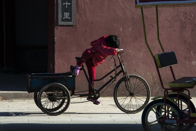 04_picfair-311603157-a-little-girl-playing-with-a-tricycle-china-768x512.jpg