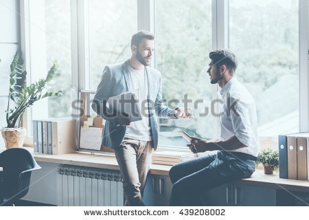 stock-photo-asking-for-professional-advice-two-young-businessmen-in-smart-casual-wear-talking-and-gesturing-439208002.jpg