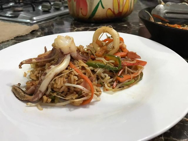 Arroz thai con chuleta y calamar con una guarnicion de vegetales.jpg