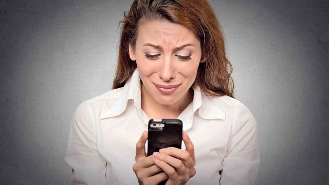 mujer-de-pelo-castano-mirando-el-celular-y-llorando.jpg