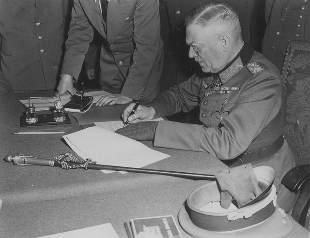 Field_Marshall_Keitel_signs_German_surrender_terms_in_Berlin_8_May_1945.jpg