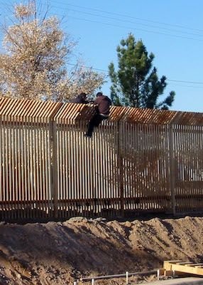 US_Navy_090317-N-5253T-016_Two_men_scale_the_border_fence_into_Mexico_a_few_hundred_yards_away_from_where_Seabees_from_Naval_Mobile_Construction_Battalions_(NMCB)_133_and_NMCB-14_are_building_a_1,500_foot-long_concrete-lined_dr.jpg