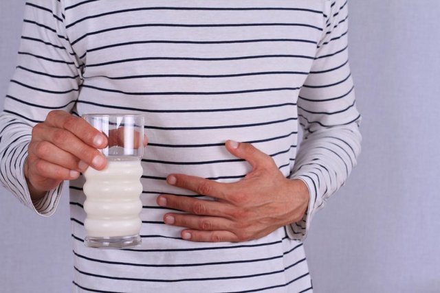 man-clutching-his-stomach-after-drinking-milk.jpg