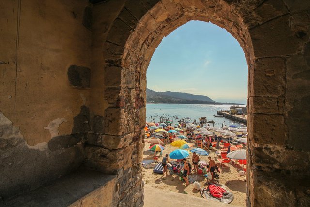 blieck-durch-einen-torbogen-auf-den-strand-von-cefalu.jpg