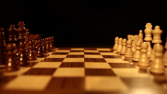 side-shot-of-a-chess-board-over-a-black-background-and-the-chess-pieces-lin_v0iu7ixol__F0000.png